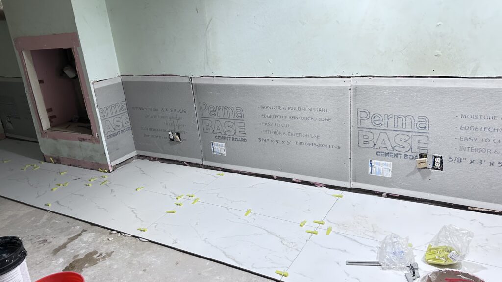 Basement moisture‑proof renovation, installing cement‑based boards along basement bottom walls for black mold and ground moisture prevention, New Jersey basement remodel project